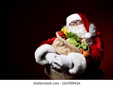 Jolly Santa Claus Is Holding A Big Bag Full Of Fruits And Vegetables. He Dreams About Enjoy A Healthy Christmas Dinner. Healthy Christmas Recipes. Christmas Diet.