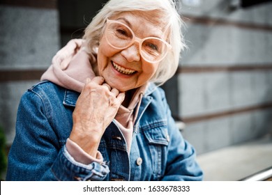 Jolly Seniour Female In Stylish Clothes And Glasses Is Spending Time Outdoors