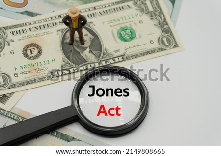 Jones Act.Magnifying glass showing the words.Background of banknotes and coins.basic concepts of finance.Business theme.Financial terms.