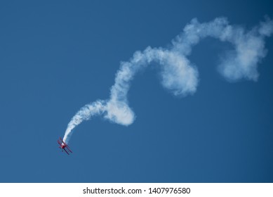 Jones Beach, New York, May 25, 2019:  Jones Beach Air Show 2019. A Oracle plane is flying in the blue sky, leaving a spiral white smoke trail. 