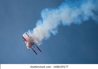 Jones Beach, New York, May 25, 2019: Jones Beach Air Show 2019. 
the body of a  red Oracle plane is covered with white smoke , as if it was burning.