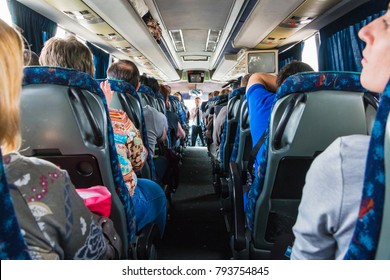 Jordan, Akaba - December 19, 2017: Tourists And A Male Tour Guide With A Microphone In The Bus