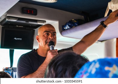 Jordan, Akaba - December 25, 2017: Male Tour Guide With A Microphone In The Touristic Bus