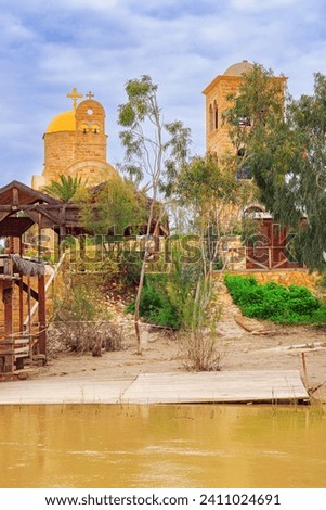 The Jordan River - state border between Israel and Jordan. Yellow water of the wide Jordan River. Place of the Baptism of Jesus Christ in Israel - Qasr el Yahud.