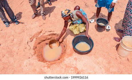 Jos East, Plateau State - May 12, 2021: African Woman Fetching Unclean and Contaminated Water from a Pond or Stream for their Daily Consumption