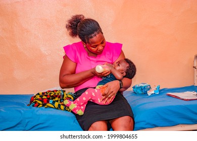 Jos, Nigeria - May 12, 2021: African Mother Feeding Her Child While She Sits On A Hospital Bed.
Mom Nursing Baby. Woman And Newborn Boy In The Hospital