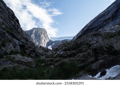 Jostedalsbreen Glacier stands majestically, with its vast icy expanse surrounded by towering, snow-capped mountains. - Powered by Shutterstock