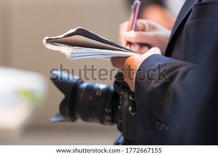 Journalist with camera and notepad on a press appointment