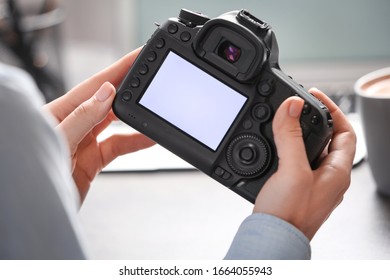 Journalist with camera at table in office, closeup - Shutterstock ID 1664055943