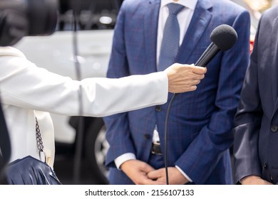 Journalist Holding Microphone Interviewing Politician Or Business Person During Media Event