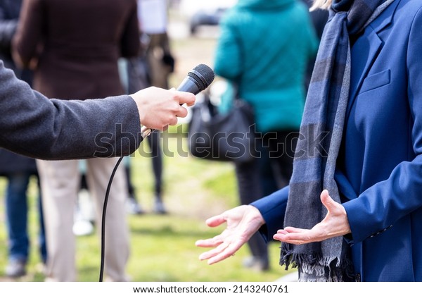 Journalist making media interview\
with elegant female politician, business woman or\
spokeswoman