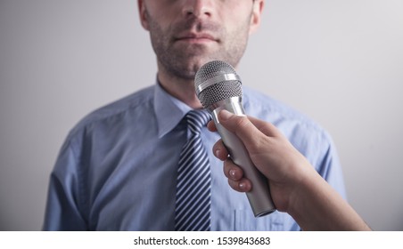 Journalist with microphone making interview.