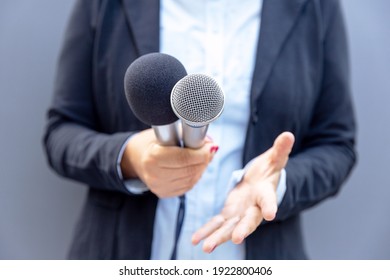 Journalist Or TV Reporter Holding Microphone And Making Media Interview. Broadcast Journalism Concept.