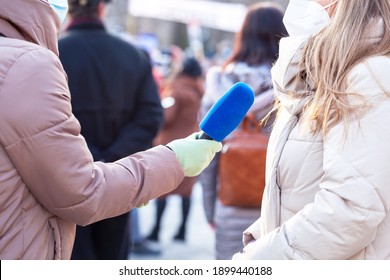 Journalist Wearing Protective Face Mask Against Coronavirus COVID-19 Disease Holding Microphone Making Media Interview During Anti-vaccination Protest