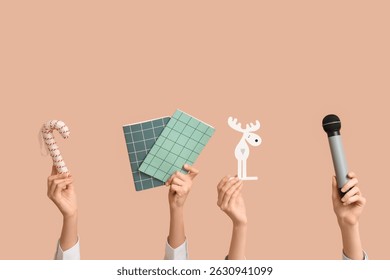 Journalist's female hands with Christmas decorations, notebooks and microphone on beige background - Powered by Shutterstock - Get 15% off with code: PIKWIZARD15