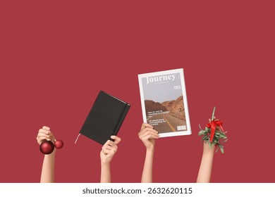 Journalist's female hands with Christmas decorations, notebook and magazine on red background - Powered by Shutterstock - Get 15% off with code: PIKWIZARD15
