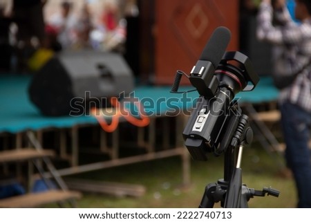 a journalist's video camera with the background of the event