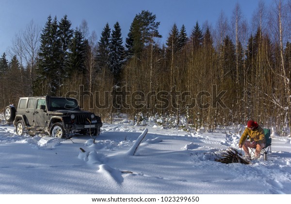 the journey by car, a tourist in the\
winter forest, the traveler in front of the\
car