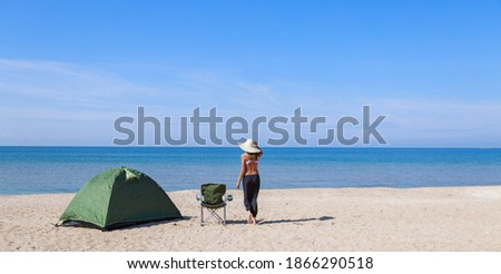 journey to the sea. camping on the beach. Vacation by the water. Men and a tent with a tourist chair on the sand