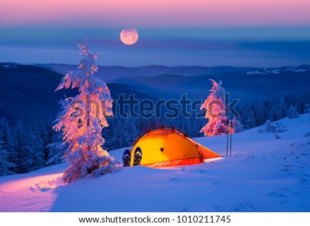 Journey through the winter alpine forests in the wild mountains of Ukraine photographic artist climber tourist equipment, powerful lantern fantasy turns the winter forest into a fairy tale