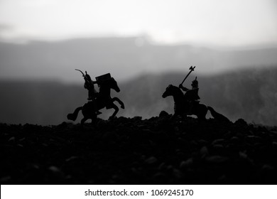 Joust between two knights on horseback. Sunset on background.
