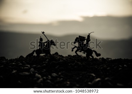 Joust between two knights on horseback. Sunset on background.