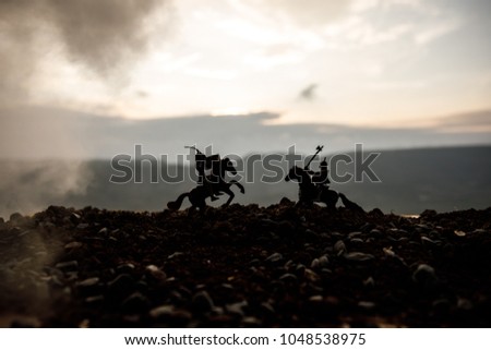 Joust between two knights on horseback. Sunset on background.