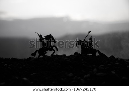 Joust between two knights on horseback. Sunset on background.