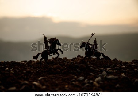 Joust between two knights on horseback. Sunset on background.