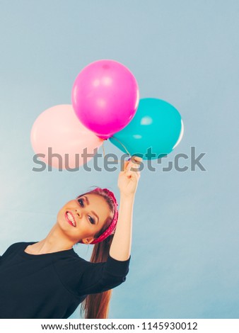 Joy fun and freedom concept. Blonde smiling woman with colorful latex balloons flying balls. Retro fashion styled girl portrait.