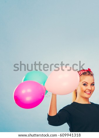Joy fun and freedom concept. Blonde smiling woman with colorful latex balloons flying balls. Retro fashion styled girl portrait.