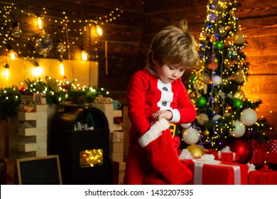 Joy And Happiness. Childhood Moments. Kid Boy Santa Hold Christmas Gift. Christmas Stocking Concept. Child Cheerful Face Got Gift In Christmas Sock. Contents Of Christmas Stocking. Oh Happy Day.