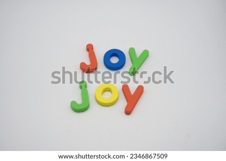 Joy in lowercase magnetic alphabet letters on a white background
