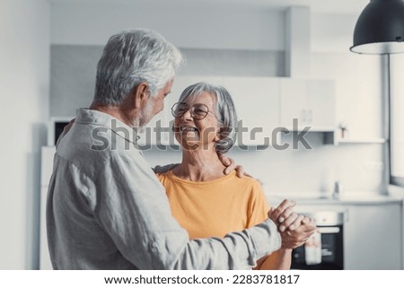 Joyful active old retired romantic couple dancing laughing in living room, happy middle aged wife and elder husband having fun at home, smiling senior family grandparents relaxing bonding together Stock foto © 