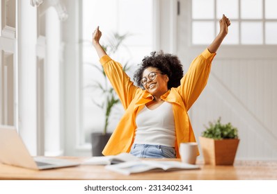 Joyful african american business woman freelancer   smiling and rejoices in victory while sitting at desk   and working at laptop screen after finishing project  in home office
 - Powered by Shutterstock