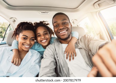 Joyful African American Family Hugging Sitting In Car During Summer Road Trip. Parents And Daughter Posing In New Auto Smiling To Camera. Transportation, New Automobile Concept