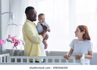 Joyful African American Man Holding Baby Girl Near Crib And Preteen Daughter