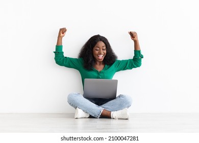 Joyful african american young woman looking for job online, got positive answer from employer, using laptop, raising hands up and screaming, happy lady gaming on Internet, copy space