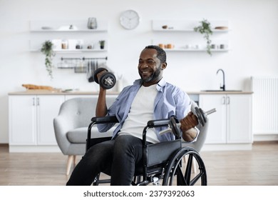 Joyful african person with physical disability holding dumbbells in arms during strength training at home. Active wheelchair user building muscles while experimenting with workout routine. - Powered by Shutterstock