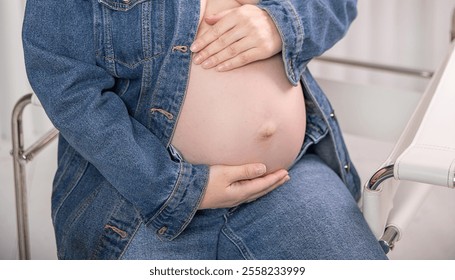 Joyful anticipation fills the air as a pregnant woman cradles her belly while waiting for a maternity appointment in a serene hospital room - Powered by Shutterstock