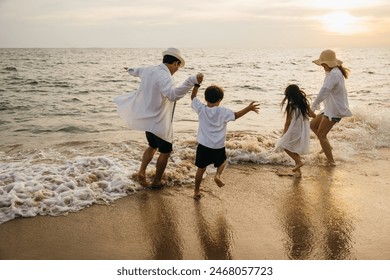 A joyful Asian family back view enjoys quality time on beach. Parents and daughters bond playing and pretending to fly with arms outstretched. carefree and happy weekend moment captured under sun. - Powered by Shutterstock