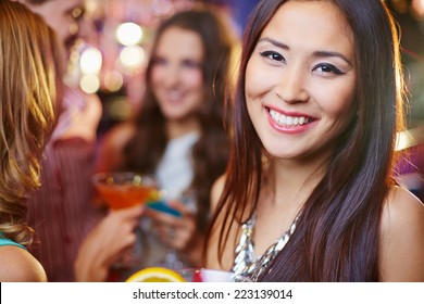 Joyful Asian Girl At A Party, Her Friends In The Background 