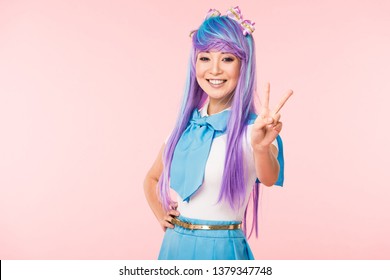 Joyful asian otaku girl showing peace sign isolated on pink