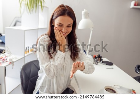 Joyful attractive woman visiting nail beauty salon