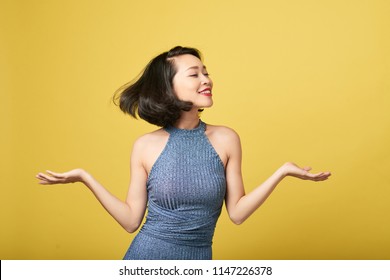 Joyful attractive young woman dancing against yellow background