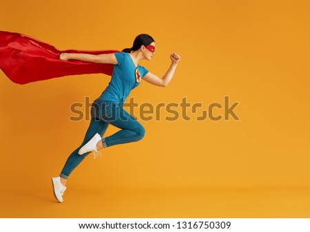 Joyful beautiful young woman in superhero costume posing on yellow background. ストックフォト © 