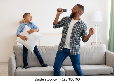 Joyful Black Dad And Little Son Singing And Dancing Together Celebrating Father's Day At Home. Happy Kid Boy Having Fun With Daddy Having Domestic Party With Karaoke. Joy Of Fatherhood Concept - Powered by Shutterstock