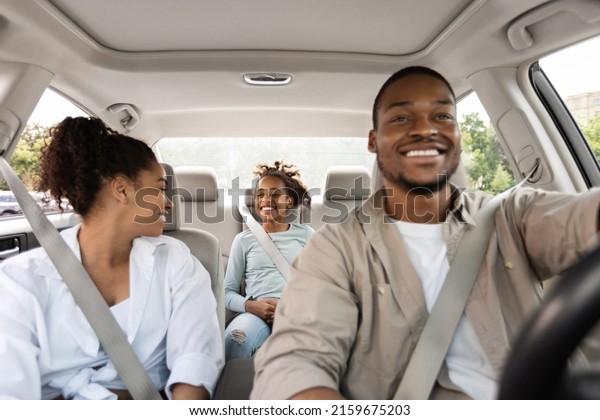 Joyful Black\
Family Driving New Car Having Ride In City. Parents And Daughter\
Sitting In Automobile Enjoying Road Trip On Vacation.\
Transportation Concept. Selective\
Focus