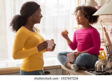 Joyful Black Mother And Little Daughter Eating Snacks And Bonding In Kitchen Together, Happy African American Woman And Her Preschooler Child Chatting And Laughing While Having A Bite, Free Space