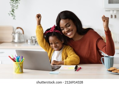 Joyful Black Mother And Little Daughter Celebrating Success With Laptop At Home, Excited African American Mom And Female Child Looking At Computer Screen And Raising Fists, Closeup Shot